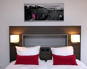 Stijlvolle slaapkamer in Hotel Bornholm, West-Terschelling, met moderne kunst en comfortabele bedden.