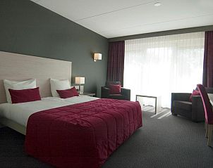 Ruime hotelkamer in Hotel Bornholm, West-Terschelling, met luxe beddengoed en zithoek.