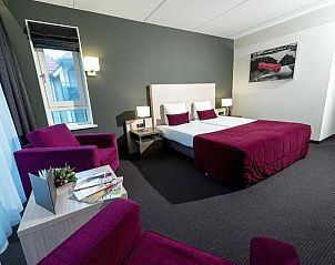 Elegante slaapkamer in Hotel Bornholm, West-Terschelling, met comfortabele stoelen en moderne faciliteiten.
