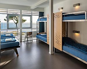 Comfortabele slaapzaal in Stayokay Hostel Terschelling met uitzicht op de zee in West-Terschelling.