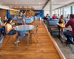 Gezellige eetzaal in Stayokay Hostel Terschelling met uitzicht op de natuur van West-Terschelling.