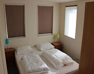 Lichte slaapkamer in TS37 appartement West-Terschelling met tweepersoonsbed en nachtkastjes.