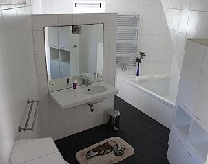 Moderne badkamer met bad en wastafel in TS37 appartement West-Terschelling, Terschelling.