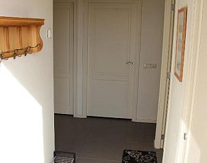 Entreehal van TS37 appartement in West-Terschelling met tegelvloer en kapstok.