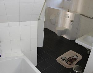 Ruime badkamer met toilet en bad in TS37 appartement West-Terschelling, Waddeneilanden.