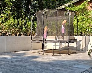 Kinderen spelen op trampoline bij Huisje in Appelscha, vakantiehuis in Friese bossen, Friesland.