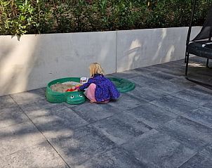 Kind speelt in zandbak bij Huisje in Appelscha, vakantiehuis in Friese bossen, Friesland.