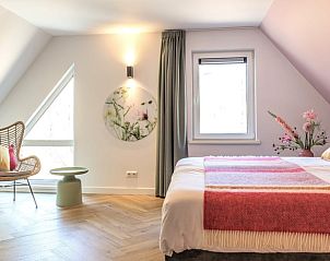 Ruime slaapkamer met zitje in Huisje in Appelscha, vakantiehuis in Friese bossen, Friesland.