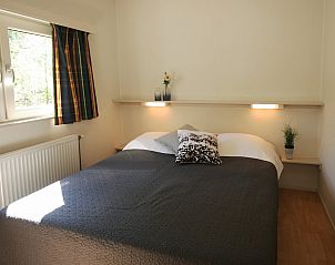 Sfeervolle slaapkamer in Chalet de Vink, Appelscha, met uitzicht op de Friese bossen. Geniet van comfort en natuur in Friesland.