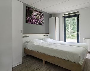 Comfortabele slaapkamer in Bungalow de Heivlinder, Appelscha, met uitzicht op de groene bossen van Friesland.