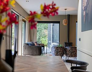 Gezellige woonkamer van Huisje in Appelscha, vakantiehuis in de Friese bossen van Friesland, met uitzicht op groene tuin en moderne inrichting.