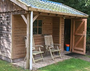 Ontspan op de veranda van Vakantiehuisje in Appelscha, een sfeervol verblijf in de Friese bossen van Friesland.
