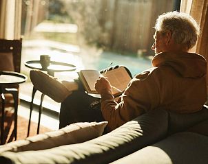 Geniet van een boek in de comfortabele binnenruimte van Unbrick One, Appelscha, Friesland.
