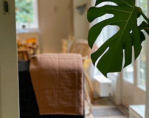 Lichte woonkamer in Huisje in Appelscha, vakantiehuis in Friese bossen, met grote ramen en groen uitzicht.