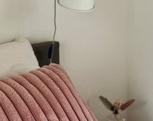 Stijlvolle slaapkamer in Huisje in Appelscha, vakantiehuis in Friese bossen, met roze accenten.