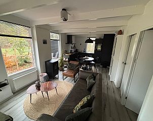 Cozy living room of Bungalow het Goudhaantje in Appelscha, Friesland, overlooking the Frisian forests and modern furnishings.
