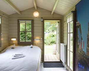 Gezellige slaapkamer in Kampeerchalet de Steenuil, Appelscha, met uitzicht op de groene Friese bossen. Perfect voor een ontspannen verblijf.