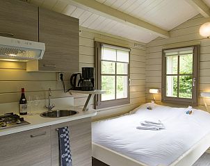 Gezellige binnenruimte van Kampeerchalet de Steenuil in Appelscha, Friesland, met comfortabel bed en keuken in de Friese bossen.