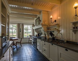 Landelijke keuken in vakantiehuis Oldeberkoop, Friesland, met uitzicht op groen.