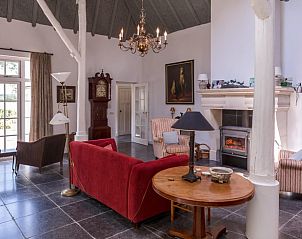 Grote woonkamer met open haard in vakantiehuis Oldeberkoop, Friese bossen.