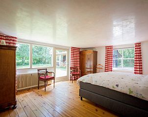 Slaapkamer met uitzicht op natuur in vakantiehuis Oldeberkoop, Friesland.