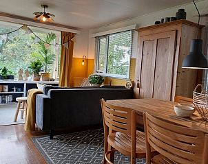 Gezellige woonkamer van Huisje in Ruigahuizen, vakantiehuis in Friese bossen, Friesland, met houten interieur en uitzicht op de natuur.