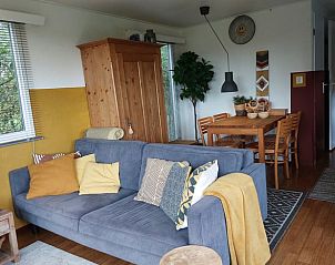 Gezellige woonkamer van Huisje in Ruigahuizen, vakantiehuis in de Friese bossen, Friesland, met comfortabele bank en eetruimte.