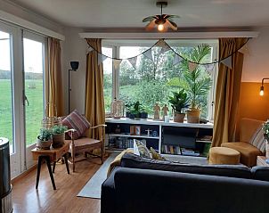 Gezellige woonkamer in Huisje in Ruigahuizen, vakantiehuis in Friese bossen, Friesland, met uitzicht op groene natuur.