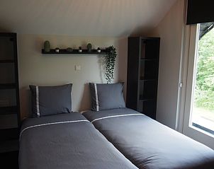 Slaapkamer met uitzicht op de natuur in vakantiehuis Noordwolde.