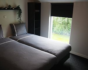 Slaapkamer met groene omgeving in vakantiehuis Noordwolde, Friesland.