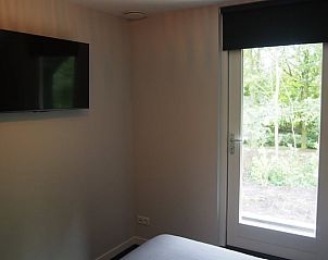 Moderne slaapkamer met uitzicht in vakantiehuis Noordwolde.