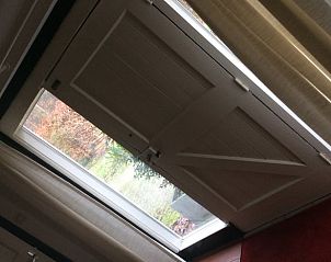 Lichtovergoten hal van vakantiehuis in Noordwolde, Friesland, met uitzicht op de natuur.