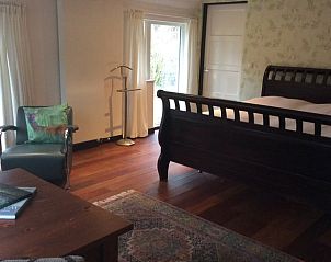 Knusse slaapkamer in vakantiehuis Noordwolde, Friesland, met houten vloer en comfortabele inrichting.