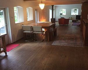 Ruime woonkamer in Vakantiehuis in Noordwolde met houten vloeren en gezellige inrichting, Friesland.