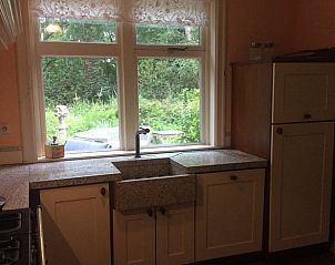 Uitzicht vanuit de keuken van Vakantiehuis in Noordwolde op de groene omgeving van Friesland.