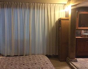 Rustieke slaapkamer in Vakantiehuis in Noordwolde met houten accenten, omgeven door Friese bossen.