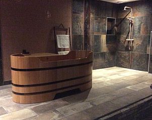 Luxe badkamer in Vakantiehuis in Noordwolde met houten bad en moderne douche, Friesland.