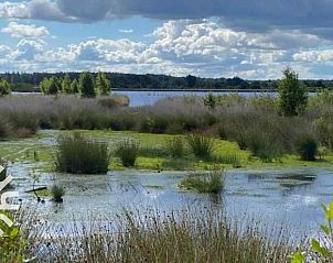 Gerumiges Wohnzimmer im Ferienhaus FR270, Oosterwolde, mit groen Fenstern und Blick auf die Natur.
