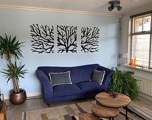 Gemtliches Wohnzimmer im Ferienhaus in Oosterwolde mit bequemem Sofa und dekorativen Elementen.