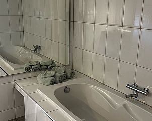Luxurises Badezimmer im Ferienhaus in Oosterwolde mit groer Badewanne und Doppelwaschbecken.