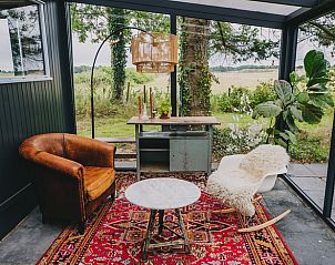Gemtliche Sitzecke im Wintergarten des Ferienhauses in Oosterwolde, mit Blick auf die friesische Landschaft.