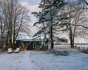 Winterlicher Charme des Ferienhauses in Oosterwolde mit verschneitem Garten in Friesland.