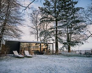 Verschneite Umgebung des Ferienhauses in Oosterwolde, mit Liegesthlen in der friesischen Landschaft.