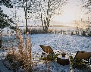 Wintergarten eines Ferienhauses in Oosterwolde mit Blick auf eine verschneite Landschaft in Friesland.