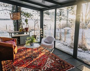 Atmosphrischer Wintergarten im Ferienhaus in Oosterwolde mit Blick auf verschneite Felder.