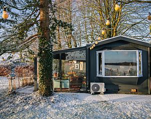 Ferienhaus in Oosterwolde im Winter, umgeben von verschneiten friesischen Wldern.