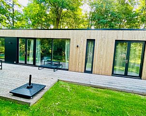 Houten veranda van Vakantiehuisje in Oosterwolde met uitzicht op de Friese natuur.