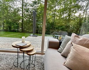 Gezellige binnenruimte van Vakantiehuisje in Oosterwolde met uitzicht op de groene omgeving.