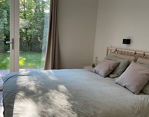 Lichte slaapkamer in Vakantiehuisje in Oosterwolde met uitzicht op de Friese bossen.