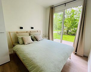 Slaapkamer met uitzicht op de natuur in Vakantiehuisje in Oosterwolde, Friesland.